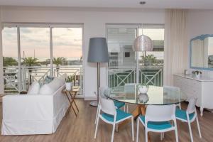 a living room with a white couch and a glass table at Marina Pez Vela Villas in Quepos