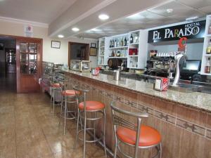 a bar in a restaurant with bar stools at Hostal Restaurante el Paraíso in Don Benito