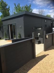 a black house with a fence in front of it at Willow Court Farm Studio South & Petting Farm, 8 mins from Legoland & Windsor, 15 mins from Lapland UK in Windsor