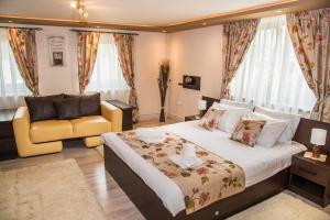 a bedroom with a large bed and a yellow chair at Casa Antonia Homestay in Şura Mică