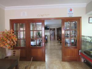 a lobby of a restaurant with wooden doors at Hostal Restaurante el Paraíso in Don Benito