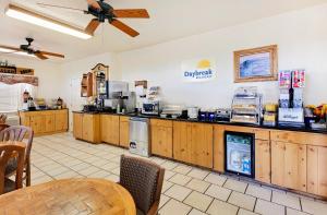 a large kitchen with wooden cabinets and a table at Days Inn by Wyndham San Angelo in San Angelo