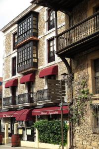 een gebouw met rode luifels aan de zijkant bij Hostal Esmeralda in Comillas