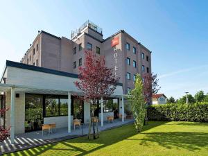 a building with a lawn in front of it at Hotel Ibis Firenze Prato Est in Campi Bisenzio