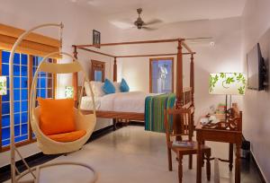 a bedroom with a swinging bed and a chair at Villa Krish in Puducherry