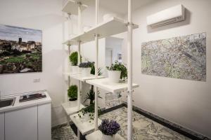 a room with white shelves with potted plants on them at Vinci House in Rome