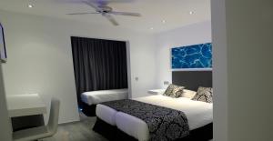 a hotel room with two beds and a ceiling fan at BG Nautico Ebeso in Ibiza Town