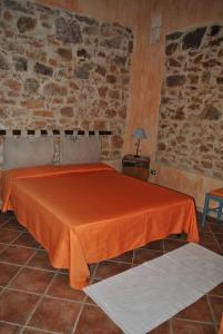 1 dormitorio con 1 cama con sábana naranja en B&B Predda Bianca, en Campanedda