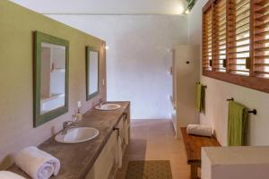 a bathroom with two sinks and a mirror at Villa Playa Tayrona, Los Naranjos in Los Naranjos