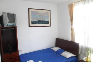 a bedroom with a blue bed and a tv at Hotel Andino Real in Bogotá