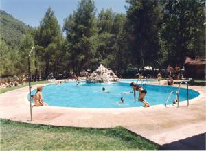 un grupo de personas en una piscina en Camping Rural Llanos de Arance, en Coto Ríos