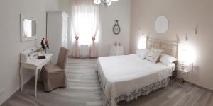 ein weißes Schlafzimmer mit einem Bett, einem Schreibtisch und einem Fenster in der Unterkunft Sweet Home in La Spezia