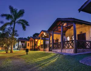a house with a palm tree in front of it at Recanto Alvorada Eco Resort in Brotas