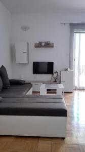 Camera bianca con letto e TV di Apartments Igor a Bibinje (Bibigne)