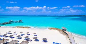 a beach with chairs and umbrellas and a pier at Sandals Royal Bahamian All Inclusive - Couples Only in Nassau