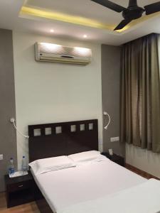 - une chambre avec un lit et un ventilateur de plafond dans l'établissement Pamposh Guest House GK II Market, à New Delhi