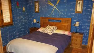 sypialnia z łóżkiem i niebieską ścianą w obiekcie Apartamentos Anateresa w mieście Mogarraz