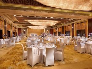 Un salón de banquetes con mesas y sillas blancas. en Wanda Vista Beijing, en Beijing 77 fotos más