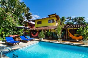 a house with a swimming pool in front of a house at Pousada Missanga in Paraty