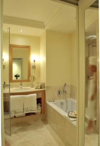 バイユーにあるヴィラ ララ ホテルのバスルーム(バスタブ、シンク、鏡付)