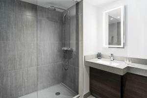 
a bathroom with a sink, mirror, and bath tub at Novotel Montreal Center in Montreal
