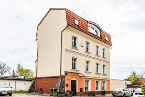 a white building with a red roof at Lake & City Apartments in Giżycko