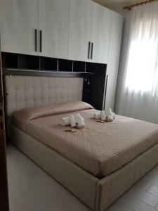 1 dormitorio con 1 cama con toallas en Blu Baita en La Maddalena