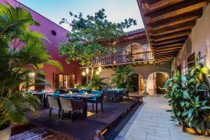 un patio al aire libre con mesas, sillas y plantas en Ananda Hotel Boutique, en Cartagena de Indias