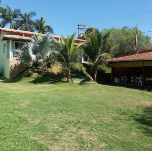 a house with two palm trees in a yard at Recanto Elohim in Itapira