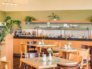 a restaurant with tables and chairs and a counter at ibis Hotel Eisenach in Eisenach