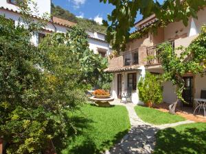 un jardín frente a un edificio con patio en Molino Del Santo, en Benaoján