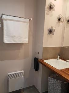 a bathroom with a white sink and a fan at Apartment Cap Larros in Gujan-Mestras