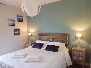 a bedroom with a large white bed with two lamps at Apartment Cap Larros in Gujan-Mestras