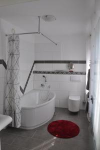 ニデッケンにあるRureifel FEWOの白いバスルーム(バスタブ、トイレ付)