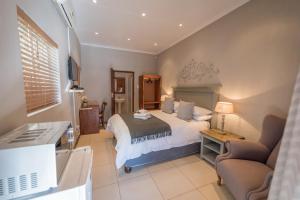 a bedroom with a bed and a desk and a couch at Chateau B&B in Piet Retief