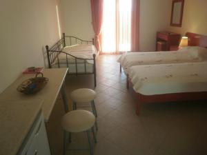 a hotel room with two beds and a table and chairs at Alkioni Studios in Trapezaki