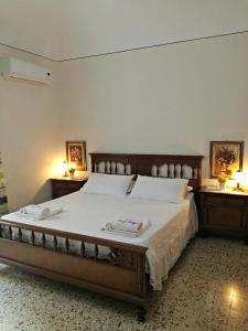 una camera da letto con un grande letto con due comodini di Casa Luigi Sergio - affitto breve a Santo Stefano di Camastra