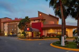 a hotel with a parking lot in front of it at Ibis Monterrey Aeropuerto in Monterrey