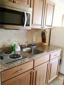 a kitchen with a sink and a microwave at Casa Del Sol Motel in Wildwood
