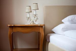 a nightstand with two lamps on it next to a bed at Fink Low Budget Rooms in Vienna
