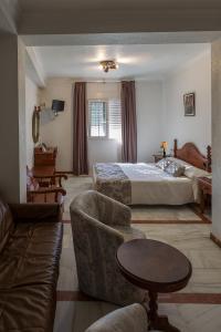 a hotel room with a bed and a couch at Hotel La Pinta in Palos de la Frontera
