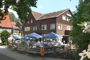 a group of tables with blue umbrellas in front of a building at Hotel-Café-Restaurant Parkhaus in Altenau