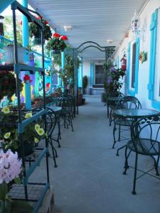 eine Terrasse mit Tischen, Stühlen und Blumen in der Unterkunft Suitcase Motel & Travel in North Wildwood