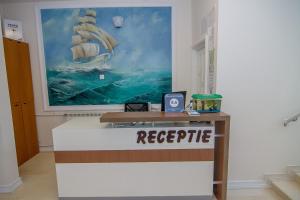 a reception desk in a room with a painting on the wall at Hotel MaRailiS Mangalia in Mangalia +67 photos