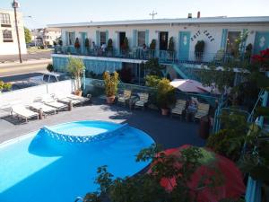 a swimming pool with two umbrellas and a building at Suitcase Motel & Travel in North Wildwood