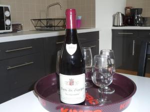 - une bouteille de vin assise sur une table avec des verres dans l'établissement Les Charmottes, à Nuits-Saint-Georges