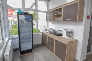 a kitchen with a counter with a refrigerator and a window at Hotel MaRailiS Mangalia in Mangalia