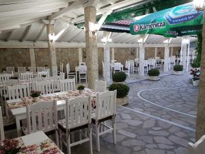 a banquet hall with white tables and white chairs at Hotel Fantasy in Lyubimets