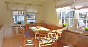 a living room with a table and chairs and windows at Ferienwohnung Rieger 1 in Braunlage
