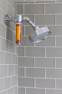 a shower faucet with an orange bottle in a bathroom at 21 Broad in Nantucket